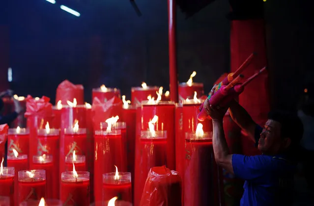 A man lights incense sticks during Lunar New Year celebrations at Dharma Bhakti temple in Jakarta, Indonesia January 28, 2017. (Photo by Darren Whiteside/Reuters)