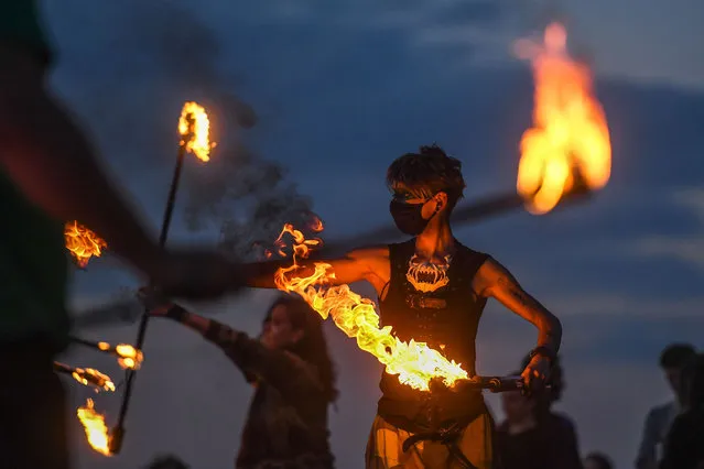 Performers from Fire Club Edinburgh mark the summer solstice during a fire festival on Calton Hill on June 21, 2021 in Edinburgh, United Kingdom. The summer solstice is the longest day in the northern hemisphere and has inspired a range of folkloric traditions across Europe. (Photo by Peter Summers/Getty Images)