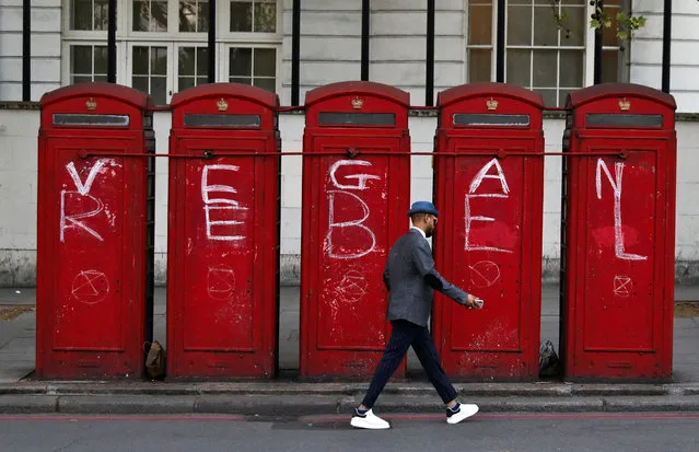 A man walks past phone boxes at Marble Arch during the Extinction Rebellion protest in London, Britain on April 20, 2019. (Photo by Kevin Coombs/Reuters)