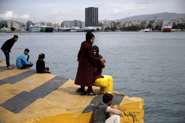 Two girls sit at a dock next to a makeshift camp for refugees and migrants at the port of Piraeus, near Athens, Greece March 24, 2016. (Photo by Alkis Konstantinidis/Reuters)