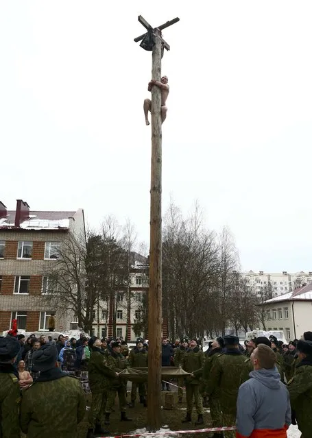 A serviceman of the Belarussian Interior Ministry's special forces unit climbs up a wooden pole to get a prize during Maslenitsa celebrations, a pagan holiday marking the end of winter  celebrated with pancake eating and shows of strength, at their base in Minsk, Belarus February 19, 2017. (Photo by Vasily Fedosenko/Reuters)
