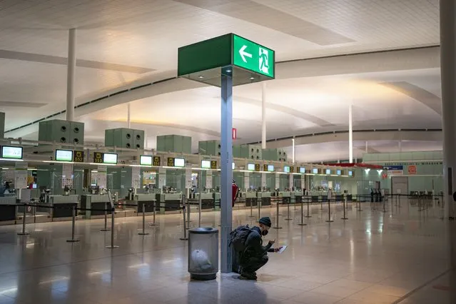 A passenger takes a photo of a passport inside a terminal of the Barcelona Airport, Wednesday, December 1, 2021. Health authorities in the Spanish capital have confirmed a second case of the omicron coronavirus variant in a 61-year-old woman who had returned from a trip to South Africa on Monday. Meanwhile lines have returned for those seeking vaccine shots in Portugal and Spain as they step up efforts to close the gap of the few residents still unvaccinated. (Photo by Joan Mateu Parra/AP Photo)