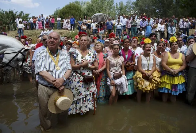 Pilgrims pray in Quema river on their way to the shrine of El Rocio in Aznalcazar, southern Spain May 21, 2015. Every spring hundreds of thousands of devotees converge at a shrine to pay homage to the Virgin del Rocio during an annual pilgrimage which combines religious fervour and festive colour. (Photo by Marcelo del Pozo/Reuters)