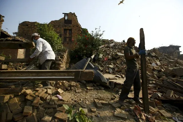 People work to clear debris from collapsed house, a month after the April 25 earthquake in Kathmandu, Nepal May 25, 2015. (Photo by Navesh Chitrakar/Reuters)