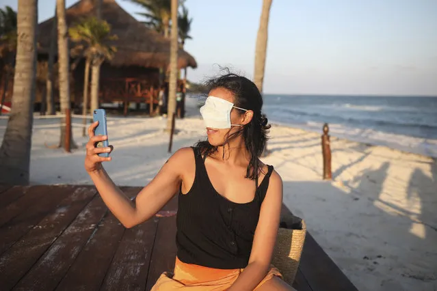 Mexico City resident Romina Montoya takes a playful selfie wearing a protective face mask over her eyes and nose, in Playa del Carmen, Quintana Roo state, Mexico, Wednesday, January 6, 2021. Concern is spreading that the critical winter holiday tourism success could be fleeting because it came as COVID-19 infections in both Mexico and the United States were reaching new heights. (Photo by Emilio Espejel/AP Photo)