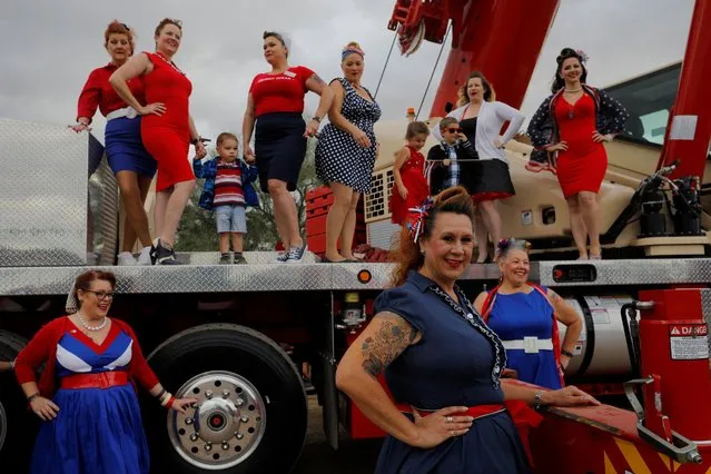 The Combat Dolls pose for a photograph on a crane at the Flags for Our Fallen rally to welcome the friends and family members of U.S. military veterans to the National Memorial Cemetery of Arizona on Memorial Day in the Maricopa County city of Phoenix, Arizona, U.S., May 27, 2019. (Photo by Brian Snyder/Reuters)