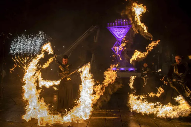 Fireshow artists perform during the Jewish holiday of Hanukkah at the Kudirkos square in Vilnius, Lithuania, Thursday, December 2, 2021. (Photo by Mindaugas Kulbis/AP Photo)