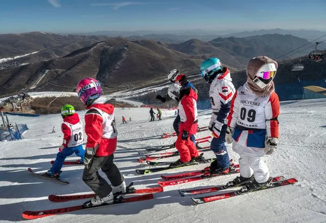 Young Chinese ski racers stand at the top of the Thaiwoo Ski Resort before it closed for the Beijing 2022 Winter Olympics, on January 2, 2022 in Chongli county, Zhangjiakou, Hebei province, northern China. The area, which will host ski and snowboard events during the Winter Olympics and Paralympics was closed off to all tourists and visitors as of January 4, 2022 and will be part of the bubble due to the global coronavirus pandemic for athletes, journalists and officials taking part in the games. The Beijing 2022 Winter Olympics are set to open February 4th. (Photo by Kevin Frayer/Getty Images)