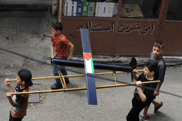 Palestinian boys carry a mockup of a Hamas drone, as they march during a protest to show their solidarity with Gaza Strip, in the Palestinian refugee camp of Ein el-Hilweh near the southern port city of Sidon, Lebanon, Friday, May 10, 2024. (Photo by Mohammed Zaatari/AP Photo)