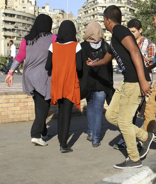 In this October 28, 2012 file photo, a youth reaches out as young girls walk past near Tahrir Square, Cairo, Egypt. Hundreds of Egyptian women and girls have come out to denounce sexual harassment and share personal stories about it on social media, breaking a taboo and raising the ire of the country’s conservative majority. In posts on Facebook and Twitter from the weekend to Wednesday, rare, candid stories focused on women’s first experiences of harassment, almost all of which occurred in childhood and some involving family members and teachers. (Photo by Mohammed Abu Zeid/AP Photo)