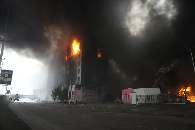 A building burns after shelling in Kyiv, Ukraine, Thursday, March 3, 2022. Russia has launched a wide-ranging attack on Ukraine, hitting cities and bases with airstrikes or shelling. (Photo by Efrem Lukatsky/AP Photo)