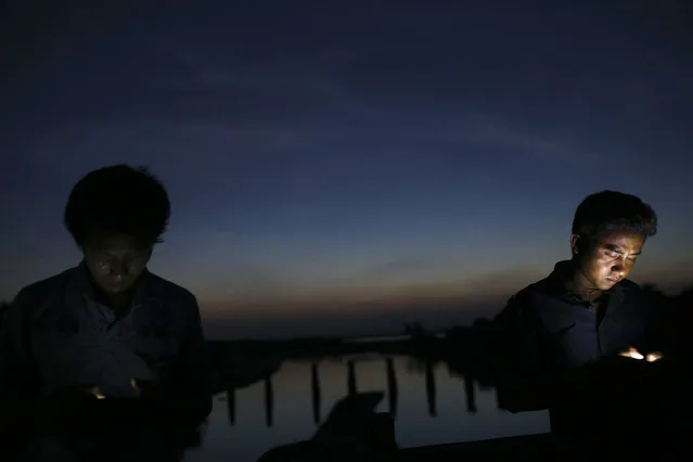 18-year-old Kyaw Min Zin (R) and his friend Chit Naing, both Rakhine Buddhists, surf the internet using a Bangladeshi network at a spot where the phone signal from neighbouring Bangladesh is believed to be received better, in Maungdaw town in northern Rakhine State November 9, 2014. (Photo by Reuters/Minzayar)