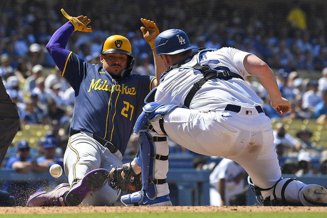 Milwaukee Brewers' Willy Adames, left, scores on a single by Blake Perkins as Los Angeles Dodgers catcher Will Smith misses the throw during the eighth inning of a baseball game Sunday, July 7, 2024, in Los Angeles. (Photo by Mark J. Terrill/AP Photo)