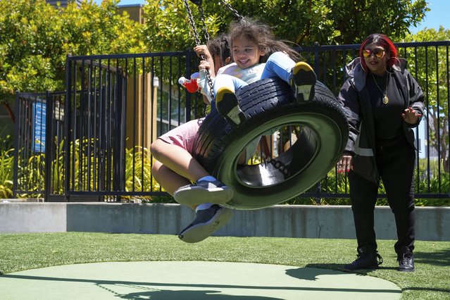 Teniah Tercero pushes her daughters Amairany, left, and Valentina on a tire swing at a park in San Francisco, May 23, 2024. Tercero is part of a group who have met regularly with a local nonprofit’s pilot program to share their stories and learn to advocate for the needs of families like theirs experiencing homelessness. (Photo by Godofredo A. Vásquez/AP Photo)