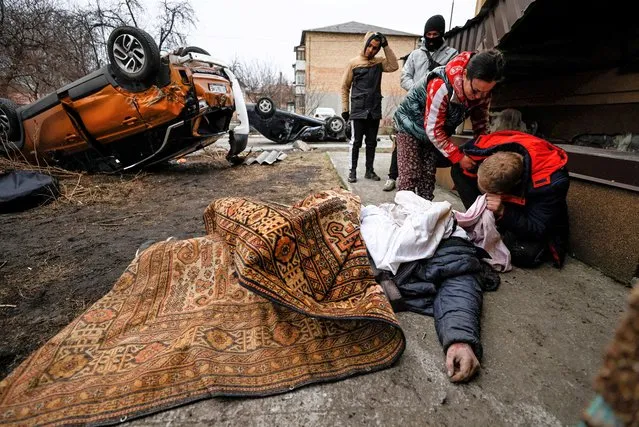 Serhii Lahovskyi, 26, mourns by the body of his friend Ihor Lytvynenko, who according to residents was killed by Russian Soldiers, after they found him beside a building's basement in Bucha, Ukraine on April 5, 2022. (Photo by Zohra Bensemra/Reuters)