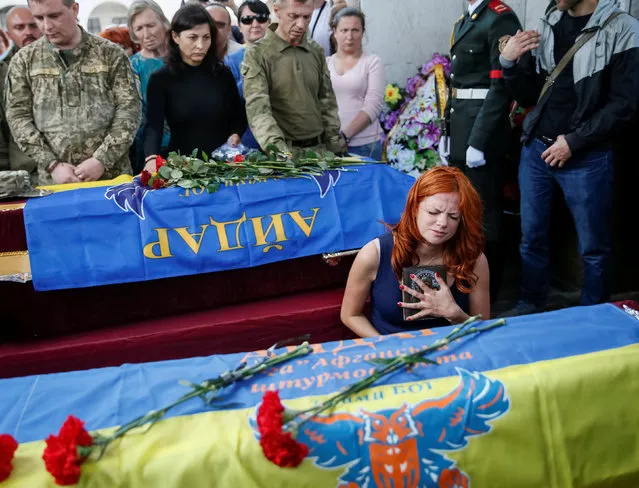 People take part in a funeral ceremony for Mykola Kuliba and Serhiy Baula, servicemen from the “Aydar” battalion, who were killed in the fighting in eastern Ukraine, at Independence Square in central Kiev, Ukraine, May 26, 2016. (Photo by Gleb Garanich/Reuters)
