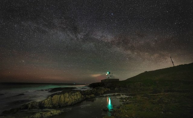 The Milky Way arcs over Bamburgh Lighthouse, in Northumberland on the North East coast of England on Wednesday, April 10, 2024. (Photo by Owen Humphreys/PA Images via Getty Images)