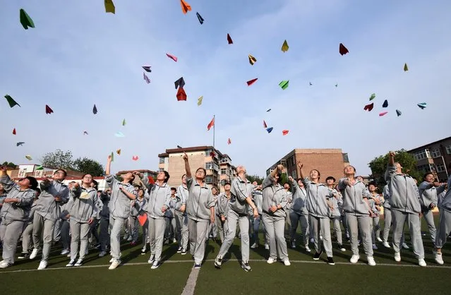 This photo taken on May 24, 2016 shows senior high students flying paper planes to release stress before the college entrance exams at a high school in Handan, north China's Hebei province. (Photo by AFP Photo/Stringer)