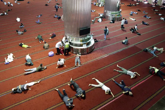 Indonesian Muslims lie down after praying to celebrate the holy month of Ramadan at Istiqlal Mosque in Jakarta, Indonesia, 02 June 2017. Muslims around the world celebrate the holy month of Ramadan by praying during the night time and abstaining from eating, drinking, and sexual acts daily between sunrise and sunset. Ramadan is the ninth month in the Islamic calendar and it is believed that the Koran's first verse was revealed during its last 10 nights. (Photo by Bagus Indahono/EPA)