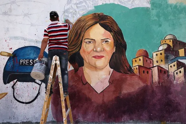 Palestinian artists paint a mural in honour of slain veteran Al-Jazeera journalist Shireen Abu Akleh in Gaza City on May 12, 2022. Abu Akleh, who was shot dead on May 11, 2022 while covering a raid in the Israeli-occupied West Bank, was among Arab media's most prominent figures and widely hailed for her bravery and professionalism. (Photo by Mohammed Abed/AFP Photo)