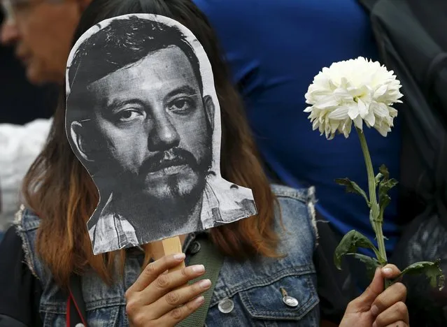 An activist holds up a picture of photojournalist Ruben Espinosa during a protest against his murder at the Angel of Independence monument in Mexico City, Mexico August 2, 2015. The prominent Mexican news photographer was among five people found dead in a middle-class neighborhood of the capital on Friday, the city's prosecutor said on Sunday. (Photo by Henry Romero/Reuters)