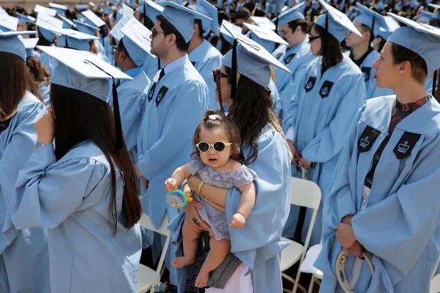 Master of Fine Arts (Visual Arts/Photography) graduate Julia Pontes, 39, holds her daughter Stella Lyra, 8 months, during the Columbia University commencement ceremony in Manhattan, New York City, U.S., May 18, 2022. (Photo by Andrew Kelly/Reuters)