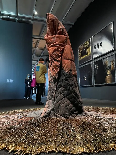 People stand near a sculpture called “ishkode (fire)” by artist Rebecca Belmore, made of empty bullet casings and a sleeping bag draped over clay to suggest the contours of a human body, at the Whitney Biennial 2022 exhibition at the Whitney Museum of American Art in New York City, New York, U.S., March 29, 2022. (Photo by Roselle Chen/Reuters)