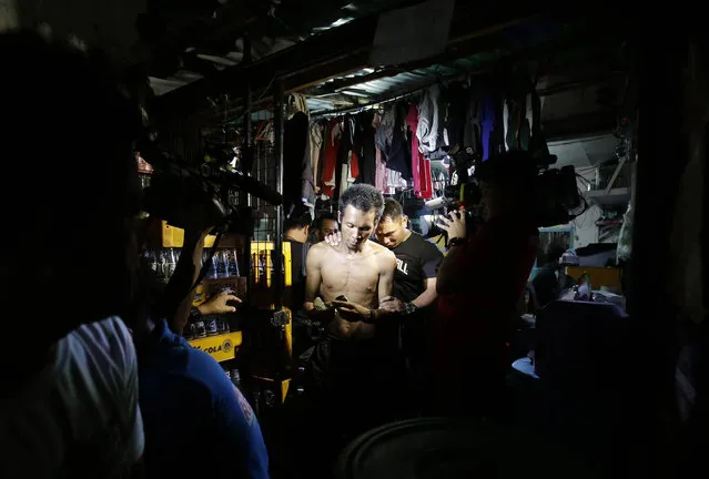 In this Wednesday June 8, 2016 photo, a Filipino man is apprehended by police for being shirtless during an operation in Manila, Philippines. In a crackdown, dubbed “Oplan Rody”, bearing Duterte’s name, police rounded up hundreds of children or their parents to enforce a night curfew for minors, and taken away drunk and shirtless men roaming metropolitan Manila's slums. The poor, who were among Duterte’s strongest supporters, are getting a foretaste of the war against crime he has vowed to wage. (Photo by Aaron Favila/AP Photo)
