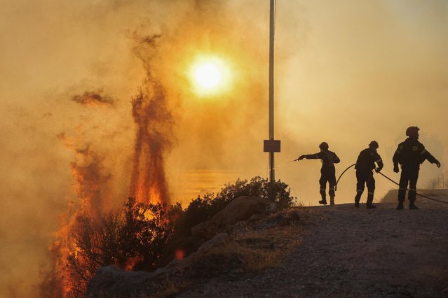 Firefighters try to extinguish a wildfire burning in Saronida, near Athens, Greece on July 17, 2023. (Photo by Stelios Misinas/Reuters)