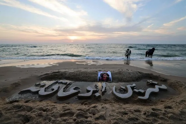 The name of slain Palestinian Al-Jazeera journalist Shireen Abu Akleh is carved in the sand, on a beach in Gaza City, on May 11, 2022. Al-Jazeera said Abu Akleh, 51, a prominent figure in the channel's Arabic news service was shot dead by Israeli troops early on May 11, 2022 as she covered a raid on Jenin refugee camp in the occupied West Bank. Israeli Prime Minister Naftali Bennett said it was “likely” that Palestinian gunfire killed her. (Photo by Mohammed Abed/AFP Photo)