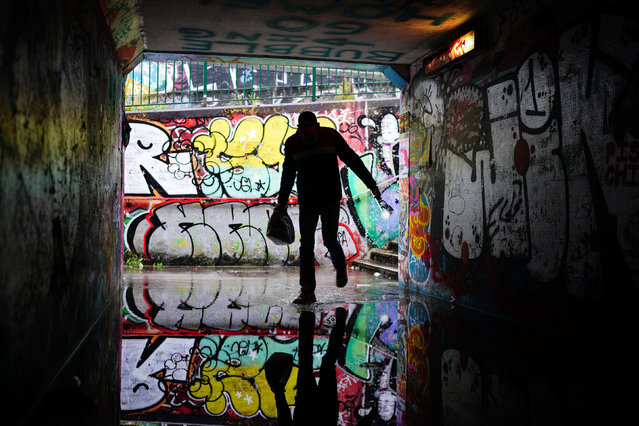 A person shelters from the rain in a flooded underpass by Lawrence Hill Roundabout, Bristol on Monday, September 23, 2024. An amber weather warning for heavy rain has come into force in parts of England, with the Met Office warning that affected areas could experience more than a month's worth of rain falling on Monday. (Photo by Ben Birchall/PA Images via Getty Images)