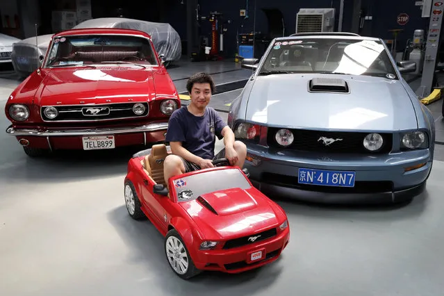 In this Wednesday, June 28, 2017, photo, Guo Xin sits on a toy Mustang as he poses with his 1966 MT GT Fastback, left, and 2005 GT convertible at his garage in Beijing. Guo operates a garage in Beijing that repairs and refits Mustangs. He founded a club in 2011 for Mustang admirers that has more than 3,000 members across China. (Photo by Andy Wong/AP Photo)