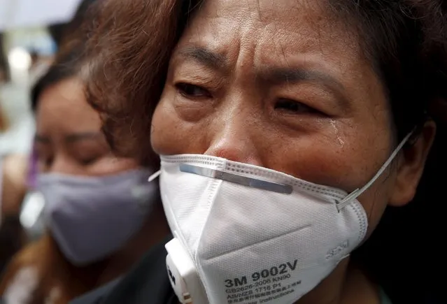 A resident evacuated from her home after last week's explosions at Binhai new district, cries as she takes part in a rally demanding government compensation outside the venue of the government officials' news conference in Tianjin, China, August 17, 2015. (Photo by Kim Kyung-Hoon/Reuters)