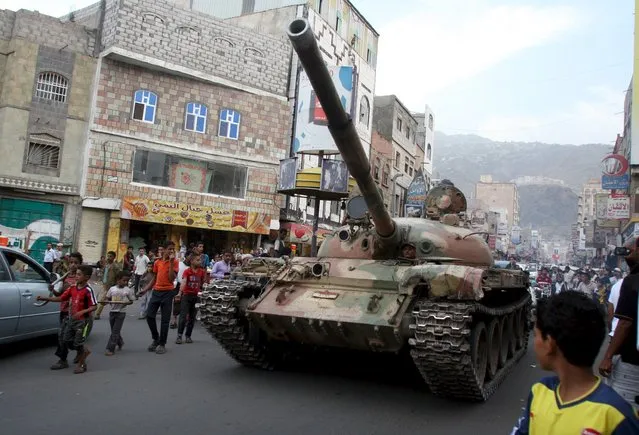 Children walk past a tank seized by militants loyal to Yemen's exiled government from Houthi militiamen in the country's central city of Taiz August 17, 2015. (Photo by Reuters/Stringer)
