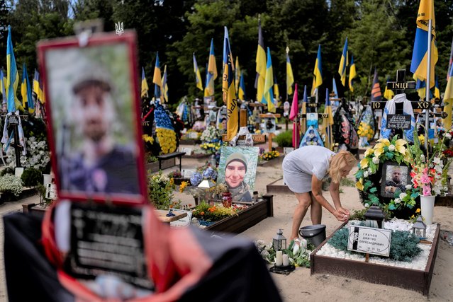 Natalie Zaichenko, 60, tends to the grave of her son, a Ukrainian soldier who was killed in the war against Russia, in Kyiv, Ukraine, Thursday, August 3, 2023. (Photo by Jae C. Hong/AP Photo)