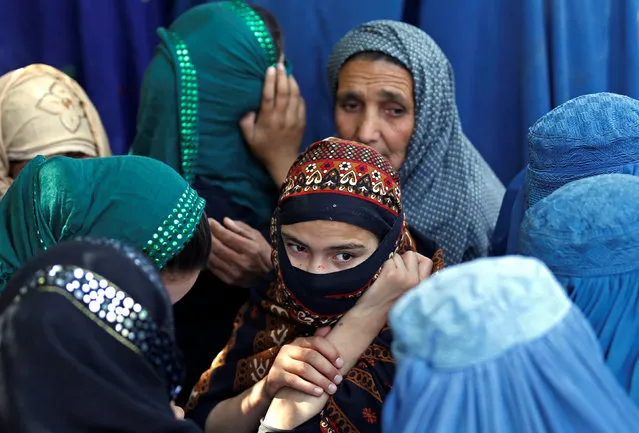 Afghan women wait to receive aid from the Afghanistan Chamber of Commerce and Industries during the month of Ramadan in Kabul, Afghanistan June 23, 2016. (Photo by Mohammad Ismail/Reuters)