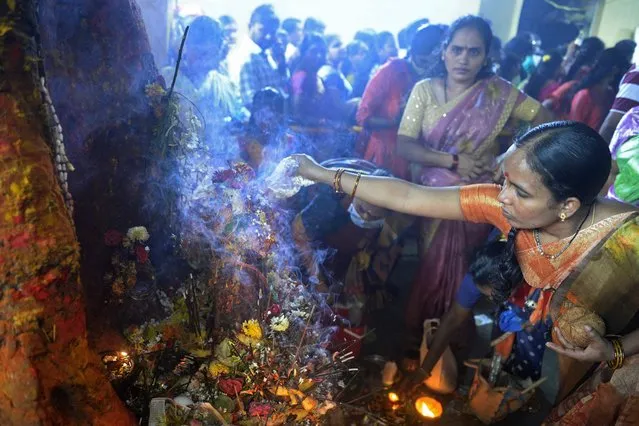 Hindu devotees offer prayers to statues of snakes on the occasion of Naga Panchami festival at a temple in Hyderabad on August 2, 2022. (Photo by Noah Seelam/AFP Photo)