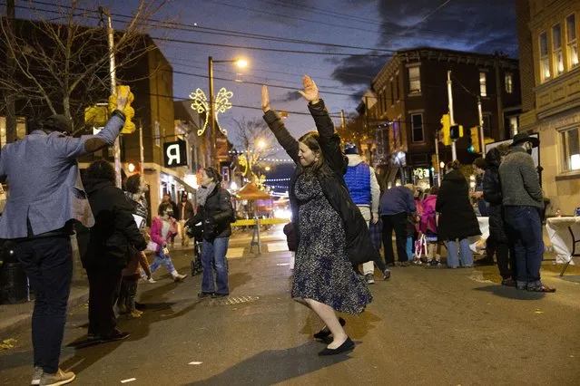 Rabbanit Dasi Fruchter, of the South Philadelphia Shtiebel, dances in the street during a public Hanukkah celebration and menorah lighting ceremony in South Philadelphia on Sunday, December 5, 2021. Fruchter is one of about a half-dozen ordained women who serve Modern Orthodox synagogues across the U.S. and one of even fewer who serve as top spiritual leaders. (Photo by Ryan Collerd/AP Photo)