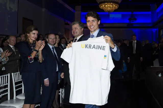 Prime Minister Justin Trudeau receives a gift from President of Ukraine, Petro Poroshenko during the Ukrainian Canadian Congress Invictus Gala, held in Toronto on Friday, September 22, 2017. (Photo by Christopher Katsarov/The Canadian Press via AP Photo)