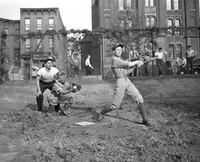 Charles Dunne swings and misses at a ball during a practice session of a P.A.L. team in Brooklyn, N.Y., June 9, 1943. The catcher is Frank Pesce and the umpire is Joe DiMaggio, not the Big League outfielder.  Joe's the coach of the team. (Photo by Ed Ford/AP Photo)