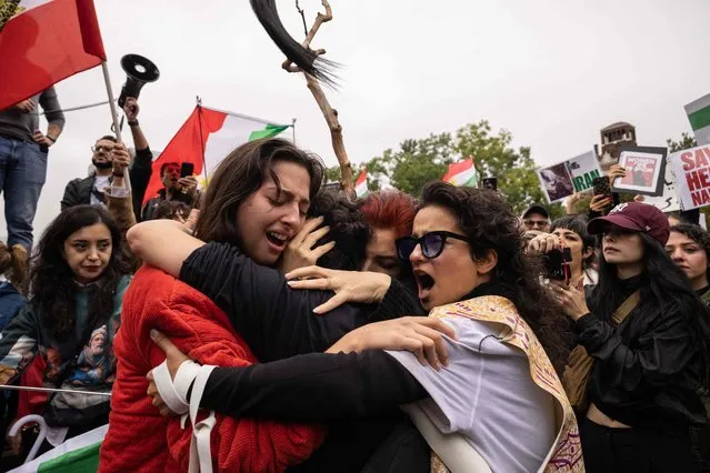 Activists hug each other after cutting their hair in protest over the death of Mahsa Amini  in the custody of the Iran's notorious morality police in New York on October 1, 2022. (Photo by Yuki Iwamura/AFP Photo)