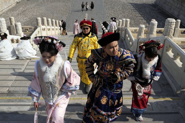 Visitors dressed in traditional costumes to look like the emperor and dowager walks up the steps at the Forbidden City in Beijing on Friday, February 21, 2025. (Photo by Ng Han Guan/AP Photo)