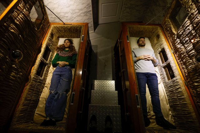 A couple of gamers, Miriam Castella and Carlos Granedo, participate in an extreme escape room named Catalepsia, which takes place inside two coffins simulating their funeral and trying to escape from them by working in pairs to solve puzzles and tricks, in Barcelona, Spain, on January 18, 2024. (Photo by Albert Gea/Reuters)
