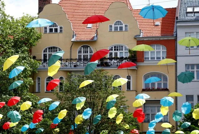 Coloured umbrellas are hanging on ropes over a square to advertise an upcoming wine festival at Berlin's Charlottenburg district in Berlin, Germany, June 30, 2020. (Photo by Fabrizio Bensch/Reuters)