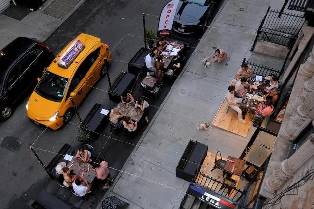 People eat outside of LENA Winebar as restaurants are permitted to offer al fresco dining as part of phase 2 reopening during the coronavirus disease (COVID-19) outbreak in the Lower East Side neighborhood of Manhattan in New York City, U.S., June 27, 2020. (Photo by Andrew Kelly/Reuters)