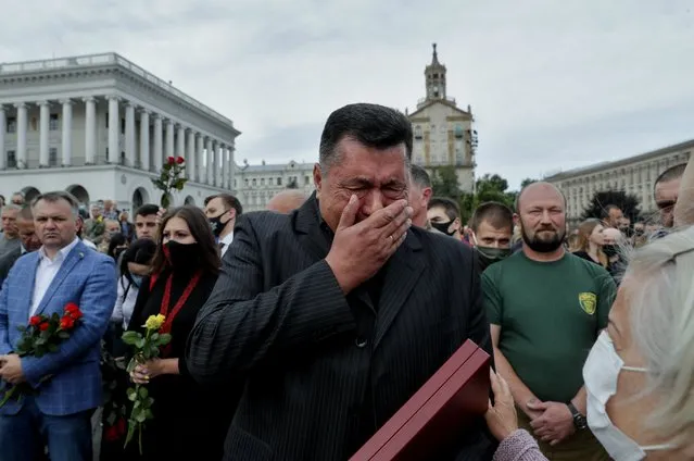 The father (C) of Ukrainian serviceman Taras Matviiv, who was reportedly killed in the armed conflict in eastern Ukraine, reacts during a funeral ceremony for his son at the Independence Square in Kiev, Ukraine, 14 July 2020. Three Ukrainian soldiers were killed and another two were wounded as pro-Russian militants mounted 18 attacks in Donbas, eastern Ukraine, on 13 July 2020. (Photo by Sergey Dolzhenko/EPA/EFE)