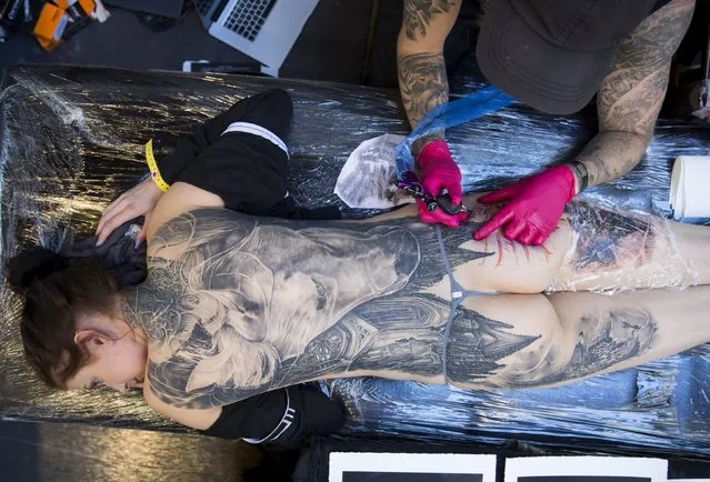 A woman has her back tattooed during the International London Tattoo Convention in east London, Britain September 26, 2015. (Photo by Neil Hall/Reuters)