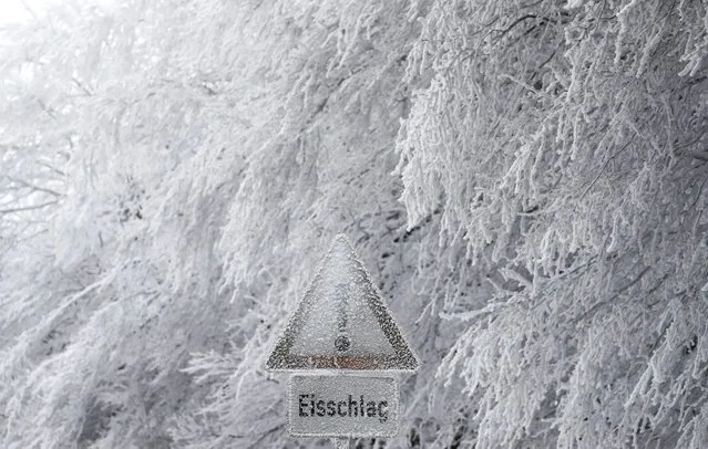 A warning sign reads “Beware of icicles” beside snow and ice covered trees near a street towards the Feldberg mountain, outside Frankfurt, Germany on December 19, 2017. (Photo by Kai Pfaffenbach/Reuters)
