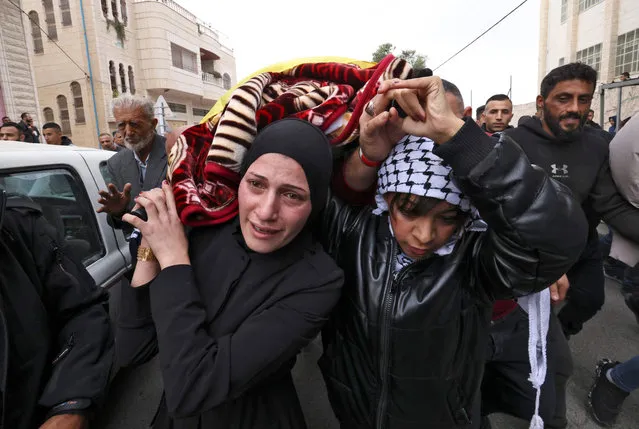 Friends and relatives of Palestinian Fulla al-Masalma, 16, mourn during her funeral in the village of Beit Awa, west of Hebron, in the occupied West Bank on November 15, 2022. Israeli forces shot dead the Palestinian teenager in the occupied West Bank the previous day, the Palestinian health ministry said, while the army confirmed raids and a shooting incident in the area. The Israeli Defence Forces reported that its soldiers had fired at a car that was speeding toward them and that “hits were identified”, but without confirming the fatality. (Photo by Hazem Bader/AFP Photo)