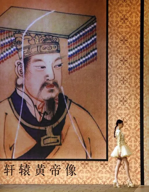 A model presents a creation by Chinese designer Zhang Zhifeng from 2014 NE TIGER Haute Couture Collection in front of a picture of the Yellow Emperor Xuan Yuan, who is considered by many to be the ancestor of the Chinese people, at China Fashion Week in Beijing, October 25, 2014. (Photo by Jason Lee/Reuters)
